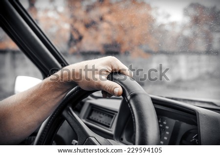 Man driving his car. Hands holding the wheel. Toned photo.