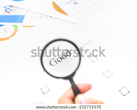 Examination business list on the office table. Hand holding a magnifying glass on the mark \