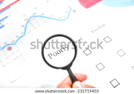 Examination business list on the office table. Hand holding a magnifying glass on the mark \
