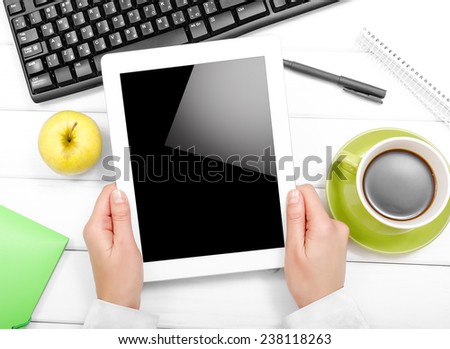 Tablet pc, apple, cup of coffee on table.