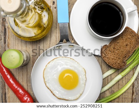Breakfast with fried eggs, toasts, oil, coffee and greens