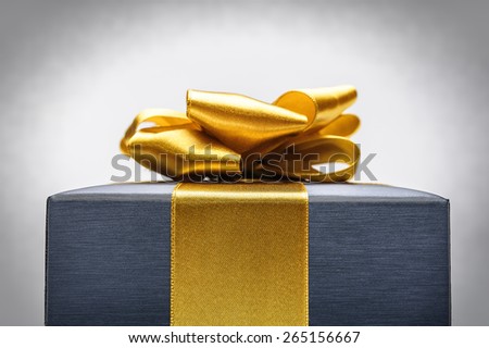 Blue box gift tied with gold ribbon with a bow