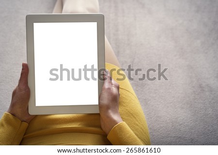 Woman on the sofa with tablet pc in hands. Toned photo.