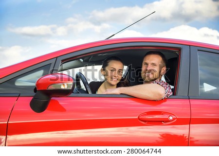 Smiling couple people in a red car