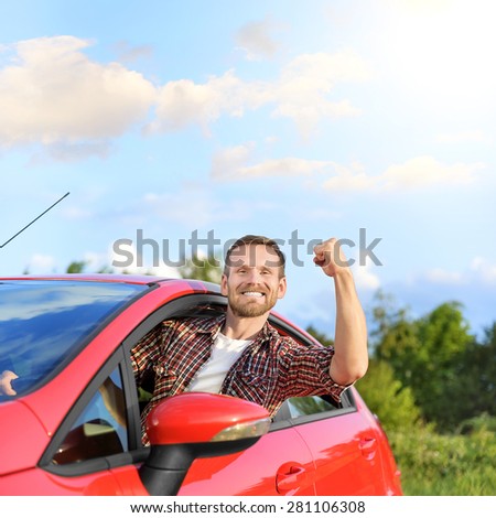 Attractive man stuck his hand out of the window of the car. Freedom concept.