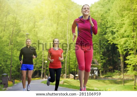 Smiling friends running outdoors. Sport fitness friendship and lifestyle concept.