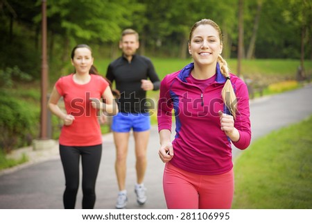 Smiling friends running outdoors. Sport, fitness, friendship and lifestyle concept.