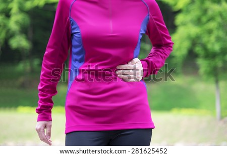Side stitch - woman runner side cramps after running. Jogging woman with stomach side pain after jogging work out.