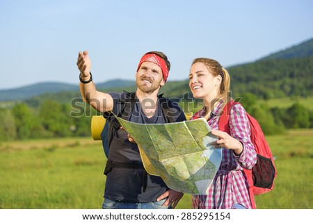 Young couple tourists with map in the park. Adventure.