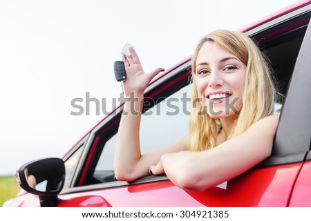 Beautiful woman in a car showing keys.
