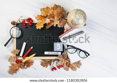 Happy teacher\'s day. Teachers day, 5 october concept.  the school blackboard and Glasses teacher books and pencils on the table, on the background of a blackboard with chalk.