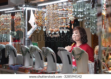 Yangon, Myanmar â?? February 28, 2014. Lady trying the necklace before buying it at germs retail center.