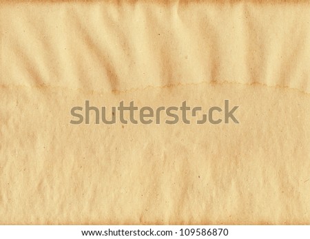 paper packing wet moist with patches of water empty space for the text background brown yellow textured and dark reflections