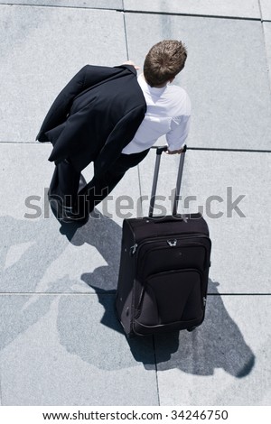 Corporate Man With Rolling Luggage Holding His Jacket