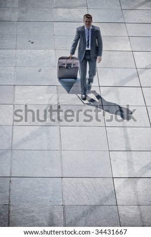 Corporate Man Walking With Luggage On Pavement