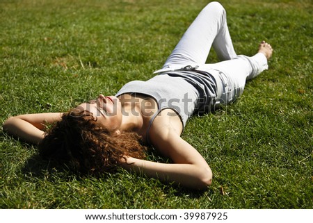 Cute Curly Girl Relaxing Lain Down On Grass