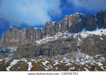Contrasting Mountain Cliff in Passo di Sella - A snow-capped mountain cliff in the mountain pass in the western Italian Dolomite.   Including beautiful high-altitude blue sky.