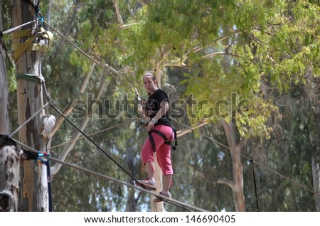 Young woman having fun on a rope park adventure course in a eucalyptus forest