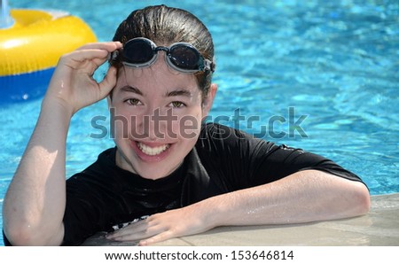 Teenager at the pool - happy and smiling 16 year old teenage girl relaxing at the pool