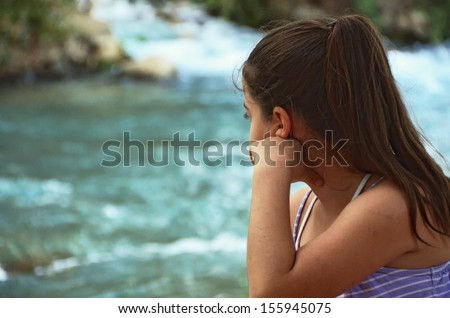 Girl watching the Jordan River - Jordan River at the Hazbani, one of the streams feeding the main Jordan in the North of Israel