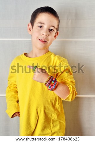 Little boy wearing colorful loom band rubber bracelets and ring