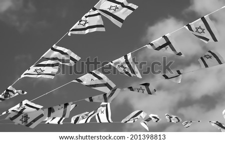 Israel flags in a chain in white and blue showing the Star of David hanging proudly for Israel\'s Independence Day (Yom Haatzmaut) - black and white