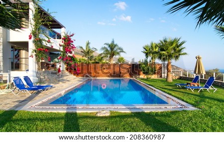 MALIA, GREECE - JULY 21, 2014: Villa with a private pool and garden on a summer vacation in golden hour light.  Malia, Crete near Hersonissos and Heraklion.