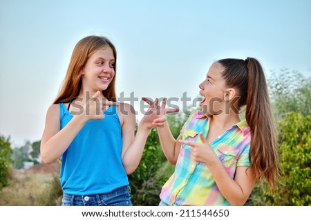 Best Friends Forever - two 12 year old teenage girls looking at each other with a surprised emotion