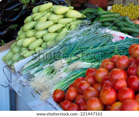 Fresh colorful produce in a Jerusalem fruit and vegetable market: green onion, tomatoes, zucchini, and eggplant