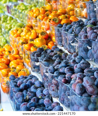 Fresh colorful produce in Jerusalem fruit and vegetable market: plum, persimmon, and other fruit