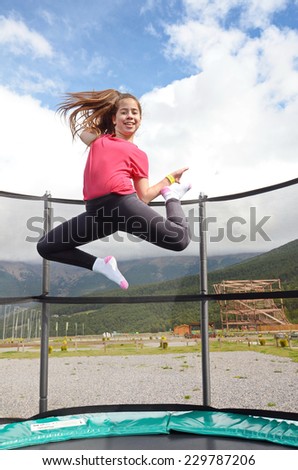 12  year old teenage girl jumping on a trampoline in the Andorra Pyrenees Mountains