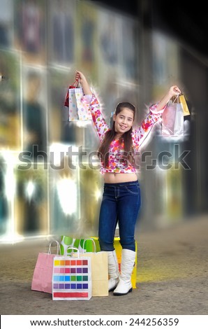 Teenage girl on a shopping spree holding shopping bags.  Illustrating shopping and fashion.