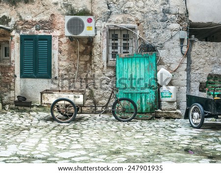 Kotor, Montenegro, Balkans, 24.01.2015. Typical paved yard with a bike-cart and lumber in the old town of Kotor, Montenegro