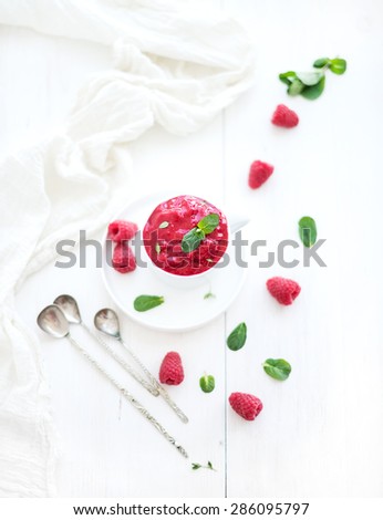 Raspberry sorbet ice-cream with mint leaves  and spoons on white background, selective focus