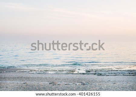 Peaceful scene of a calm sea at sunset, pastel colors