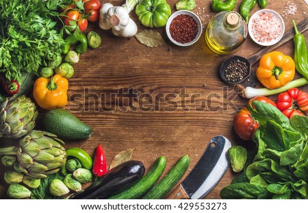 Fresh raw vegetable ingredients for healthy cooking or salad making on rustic wood background, top view, copy space. Diet or vegetarian food concept
