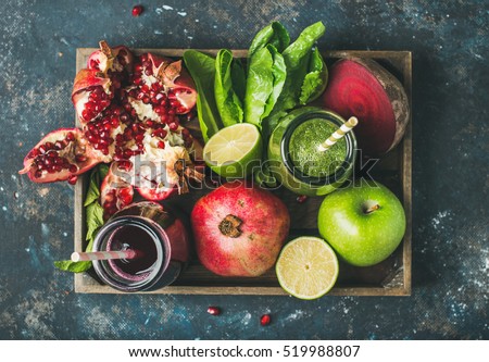 Green and purple fresh juices or smoothies with fruit, greens, vegetables in wooden tray, top view, selective focus. Detox, dieting, clean eating, vegetarian, vegan, fitness, healthy lifestyle concept