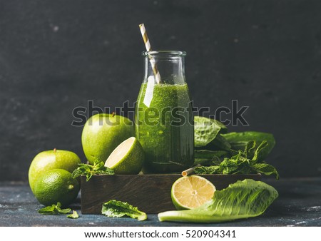 Green smoothie in glass bottle with apple, romaine lettuce, lime and mint, dark background, selective focus. Detox, dieting, clean eating, vegetarian, vegan, fitness or healthy lifestyle concept