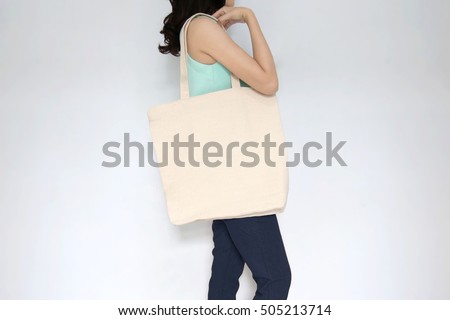 Mock-up. Girl is holding blank canvas tote bag. Handmade eco shopping bag for girls.