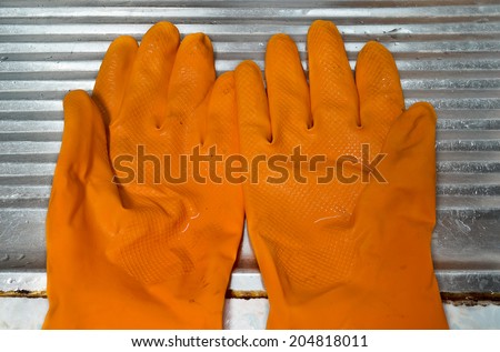 Wet dirty orange rubber gloves are on sink.