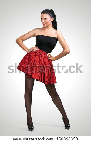 Pin-up girl in red skirt on grey background