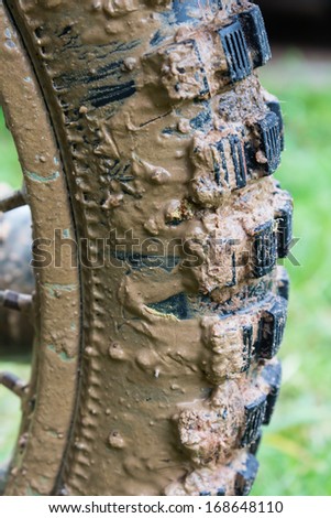 Wet clay on black  motorbike tyre