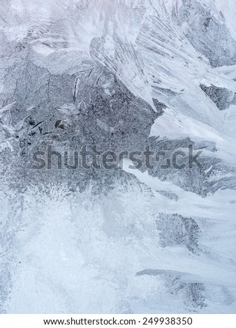 Window glass with hoarfrost drawings, taken from inside on the building in cold winter weather - abstract winter background