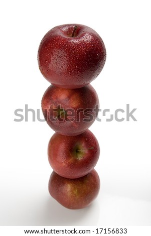 Four red apples stacked on one another