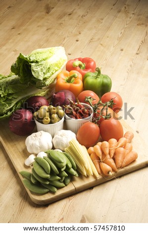 Vegetables on a wooden kitchen table, lit with a large light source from the right.