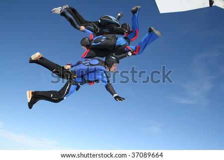 Three skydivers jump from a plane
