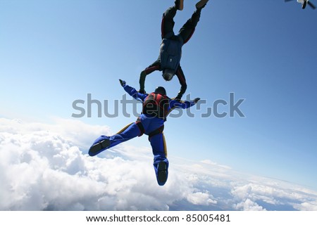 Two skydivers exit an airplane high up in the air