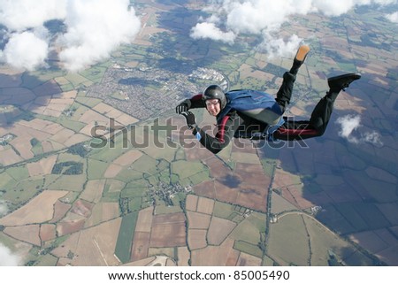 Skydiver in freefall high up in the air on a sunny day