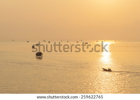 Silhouette fishing boat out to fish sunrise at Bangtaboon Bay, Thailand.