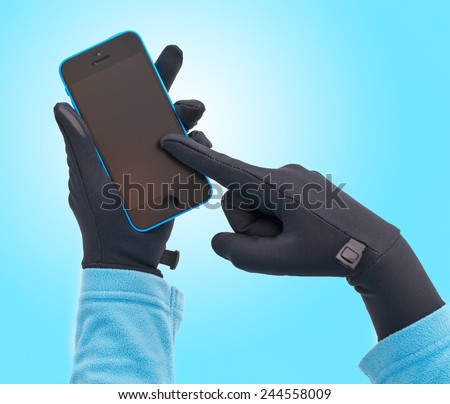 Human hands in touchscreen gloves holding smart phone.